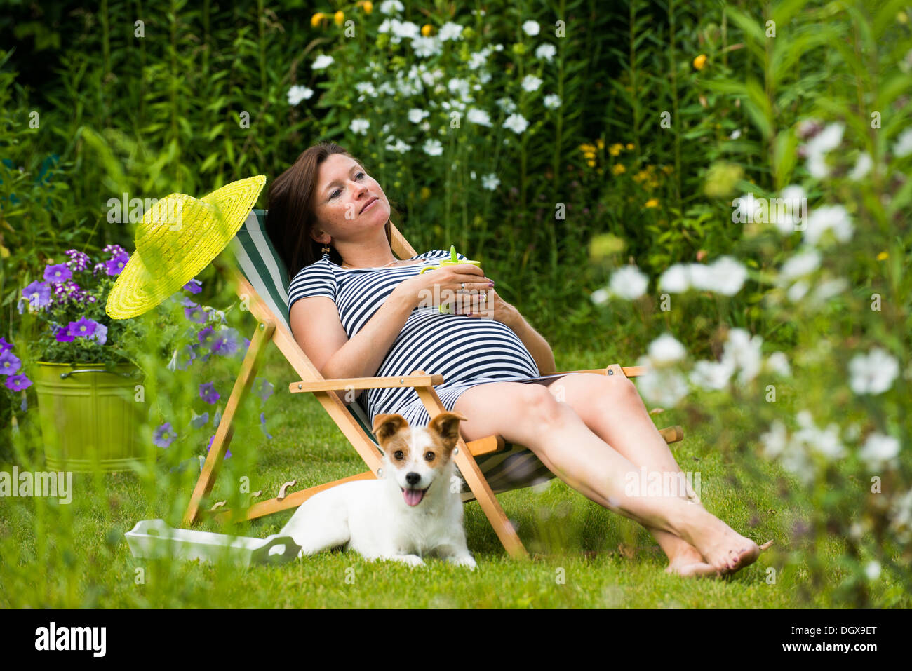 Pregnant woman relaxing in the garden Stock Photo - Alamy