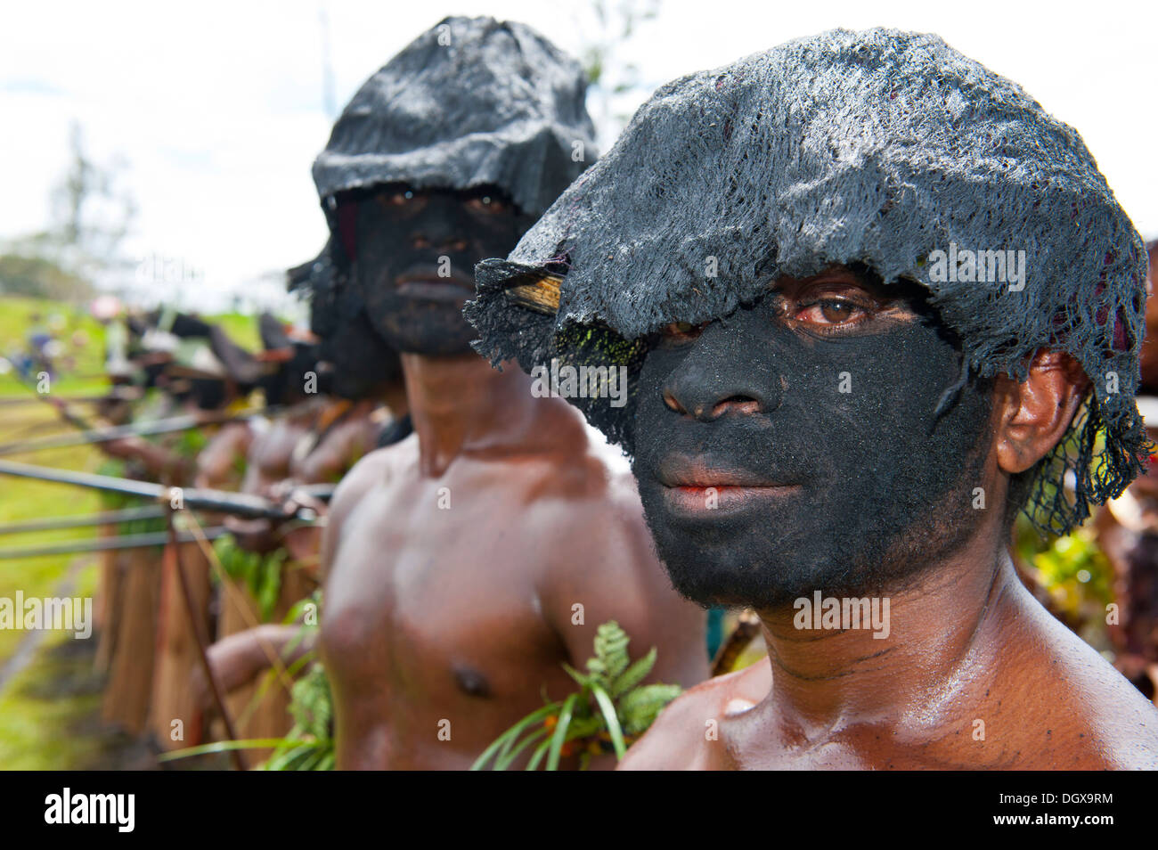 Members of a tribe with black painted faces at the traditional sing-sing gathering, Hochland, Mount Hagen Stock Photo