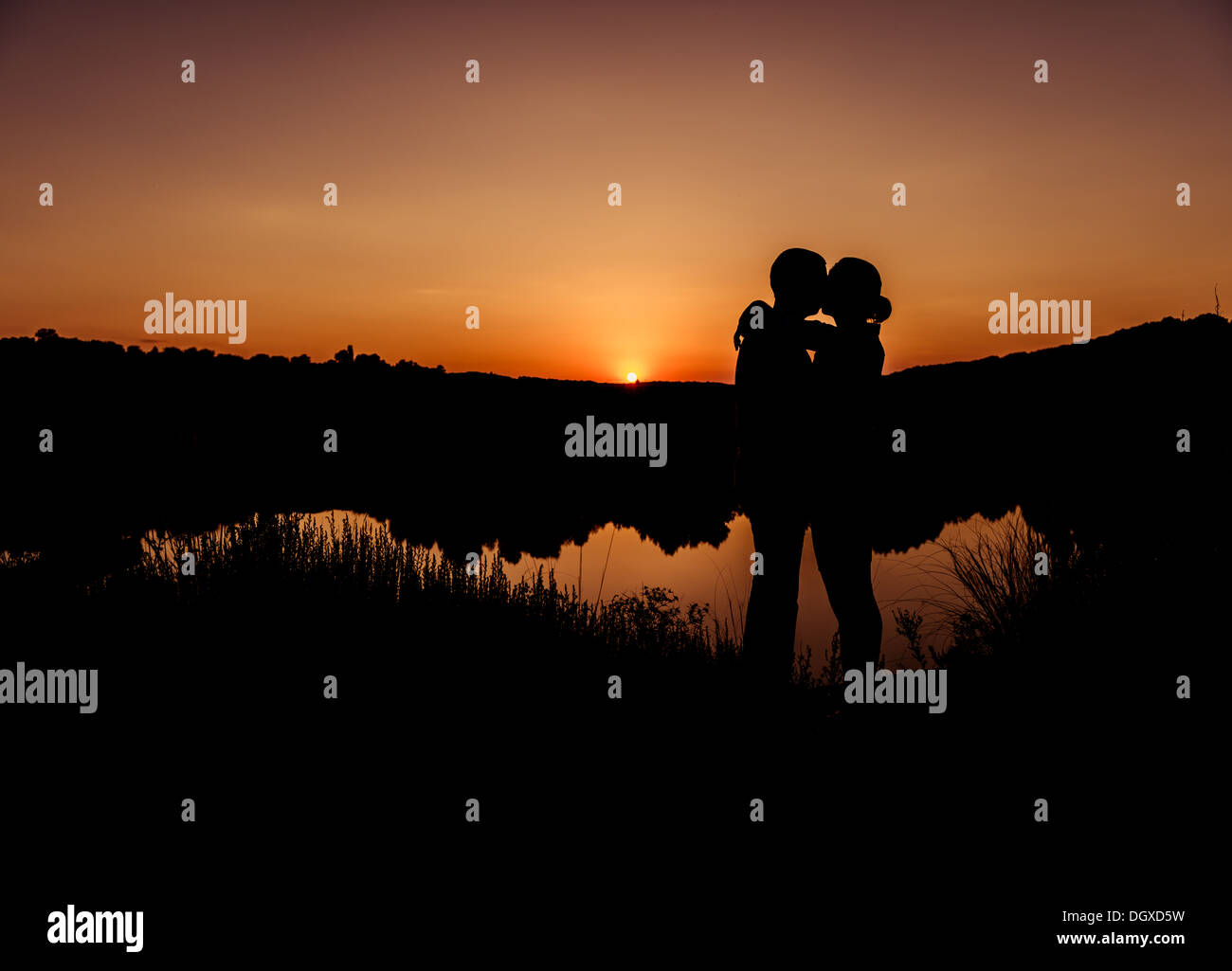 sunset kiss of a couple silhouettes man and woman at riverside summer ...