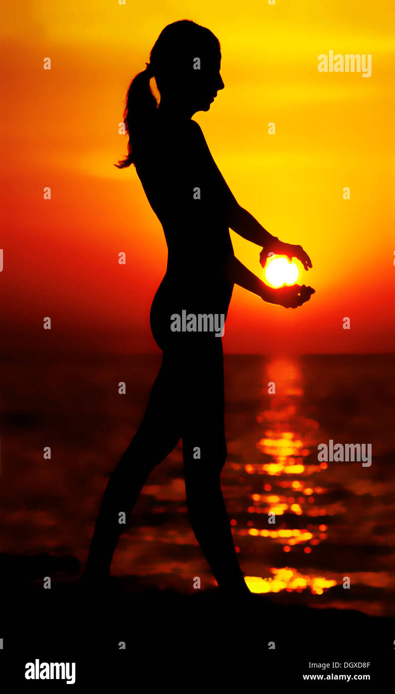 Woman holding the sun with backlighting, silhouette of a woman at ...