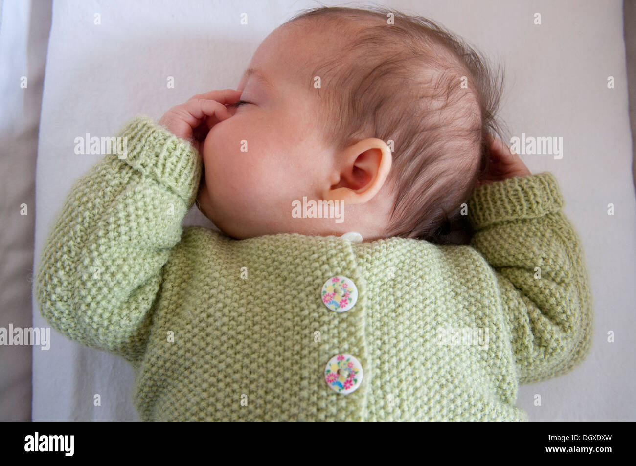 Little baby girl asleep in her crib and sucking her thumb Stock Photo