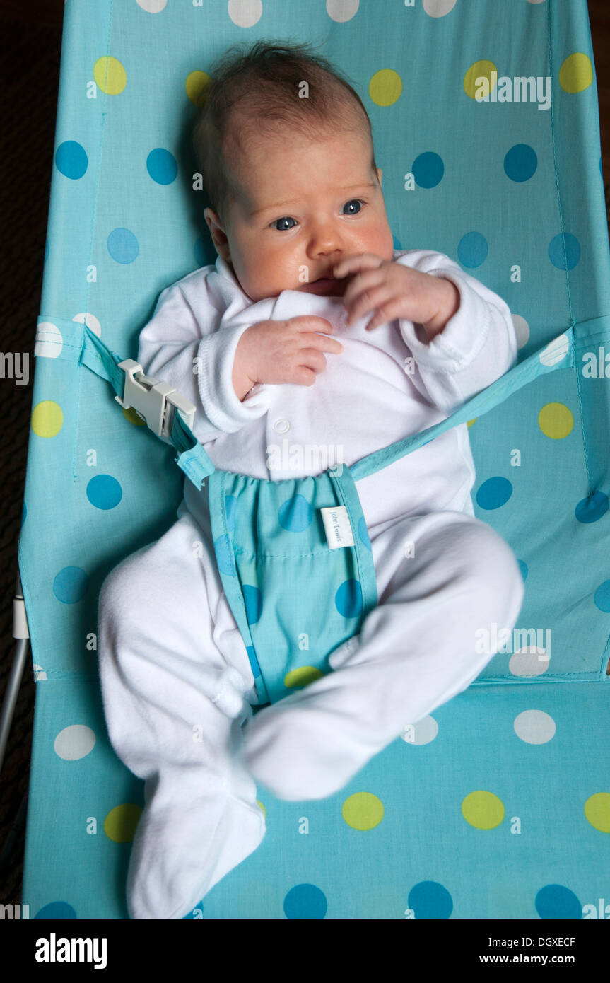 Little baby girl in a baby bouncer looking worried Stock Photo Alamy