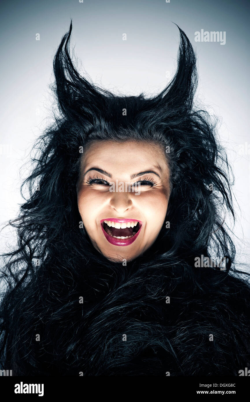 Laughing young woman dressed as a devil with horns, Austria Stock Photo