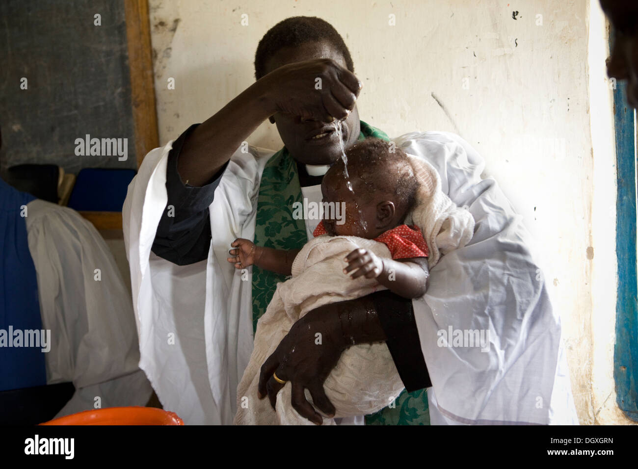 A child is christened in a church by a priest in Amuria, Uganda, East Africa. Stock Photo