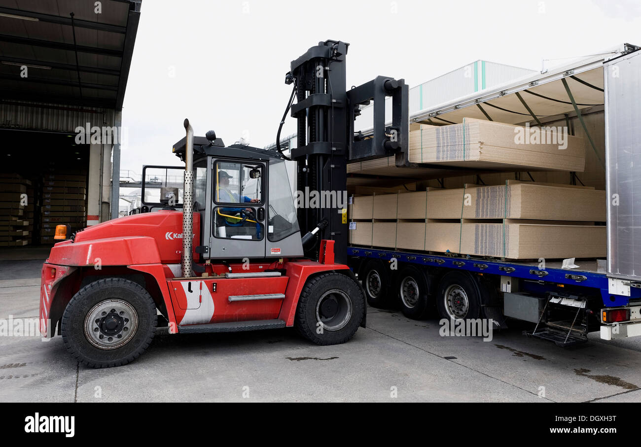 Fork lifter loading the finished particle boards onto a truck, Pfleiderer AG factory at the headquarters in Neumarkt Stock Photo