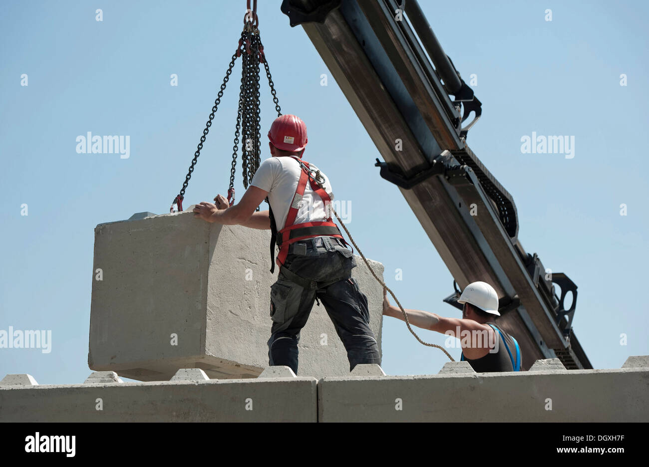 Construction workers stacking concrete blocks during a building site