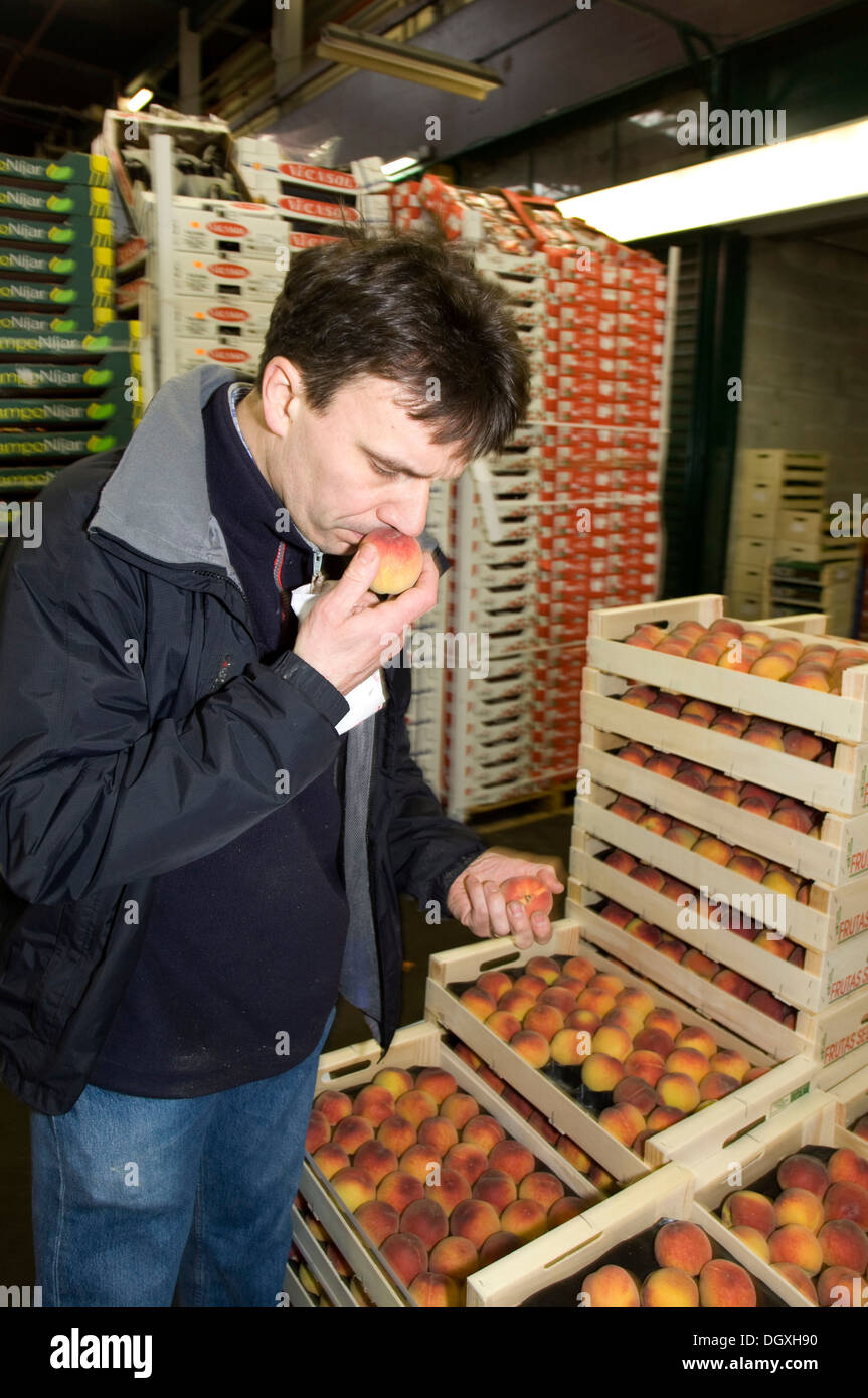 Francois Pasteau, chef from the L'Epi Dupin restaurant, controlling a peach in the fruit and vegetables hall, Pavillon des Stock Photo