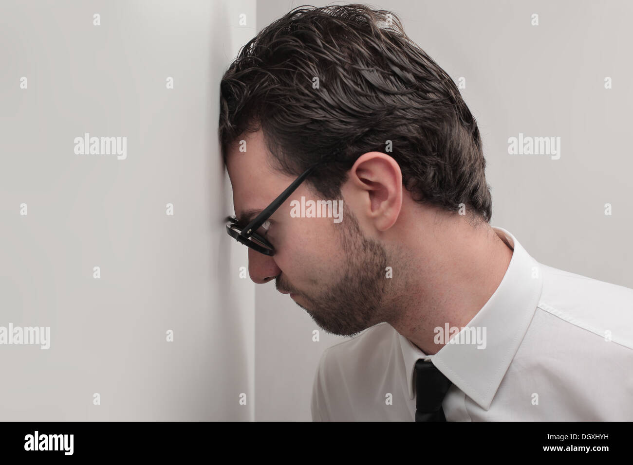 Office worker banging his head against a wall Stock Photo - Alamy
