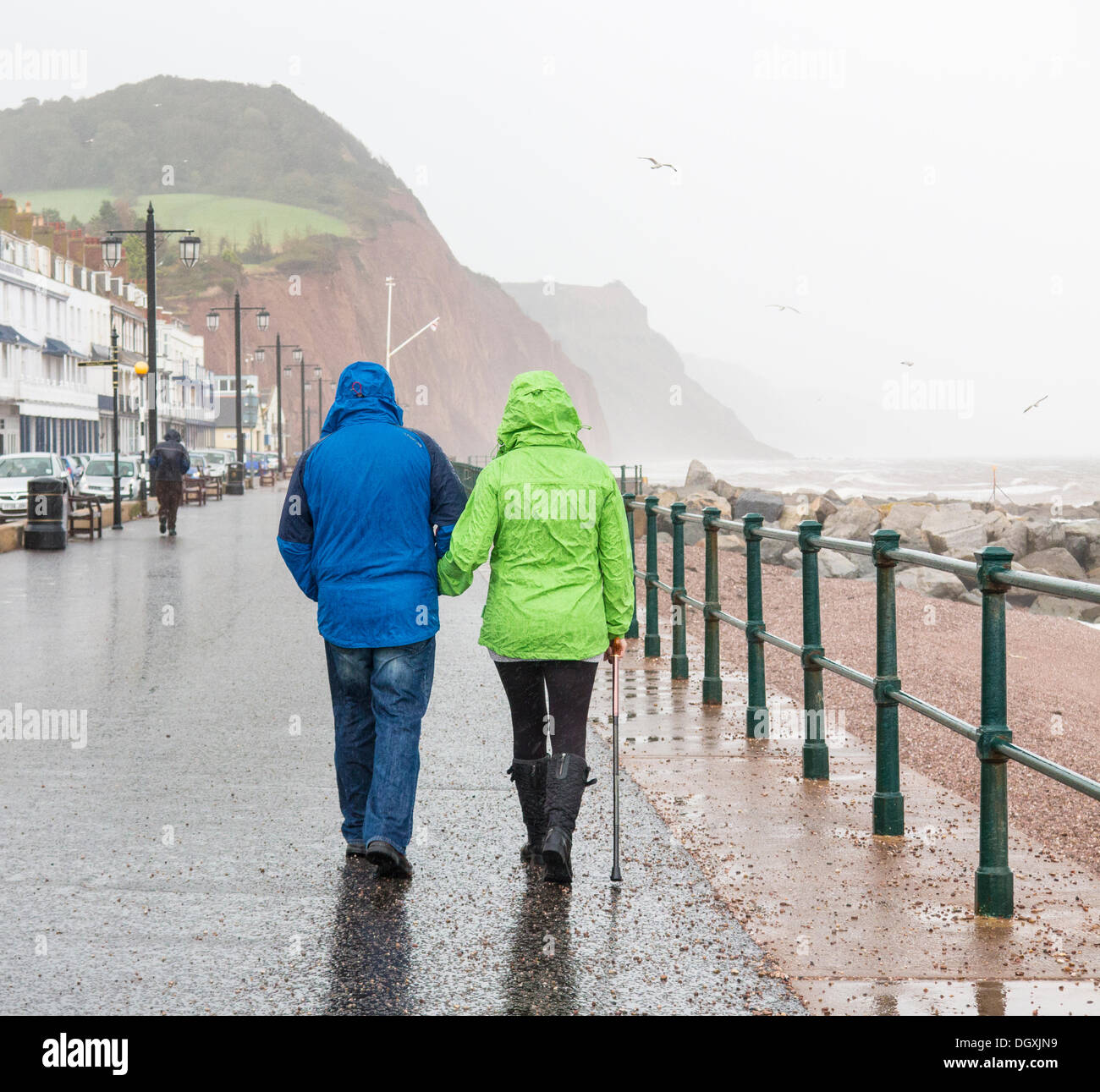 Sidmouth, Devon, UK . 27th Oct, 2013. Stormy weather as St. Jude approaches. Rain, stormy seas and gale force winds batter walkers on Sidmouth seafront as the storm approaches. Credit:  Lightworks Media/Alamy Live News Stock Photo