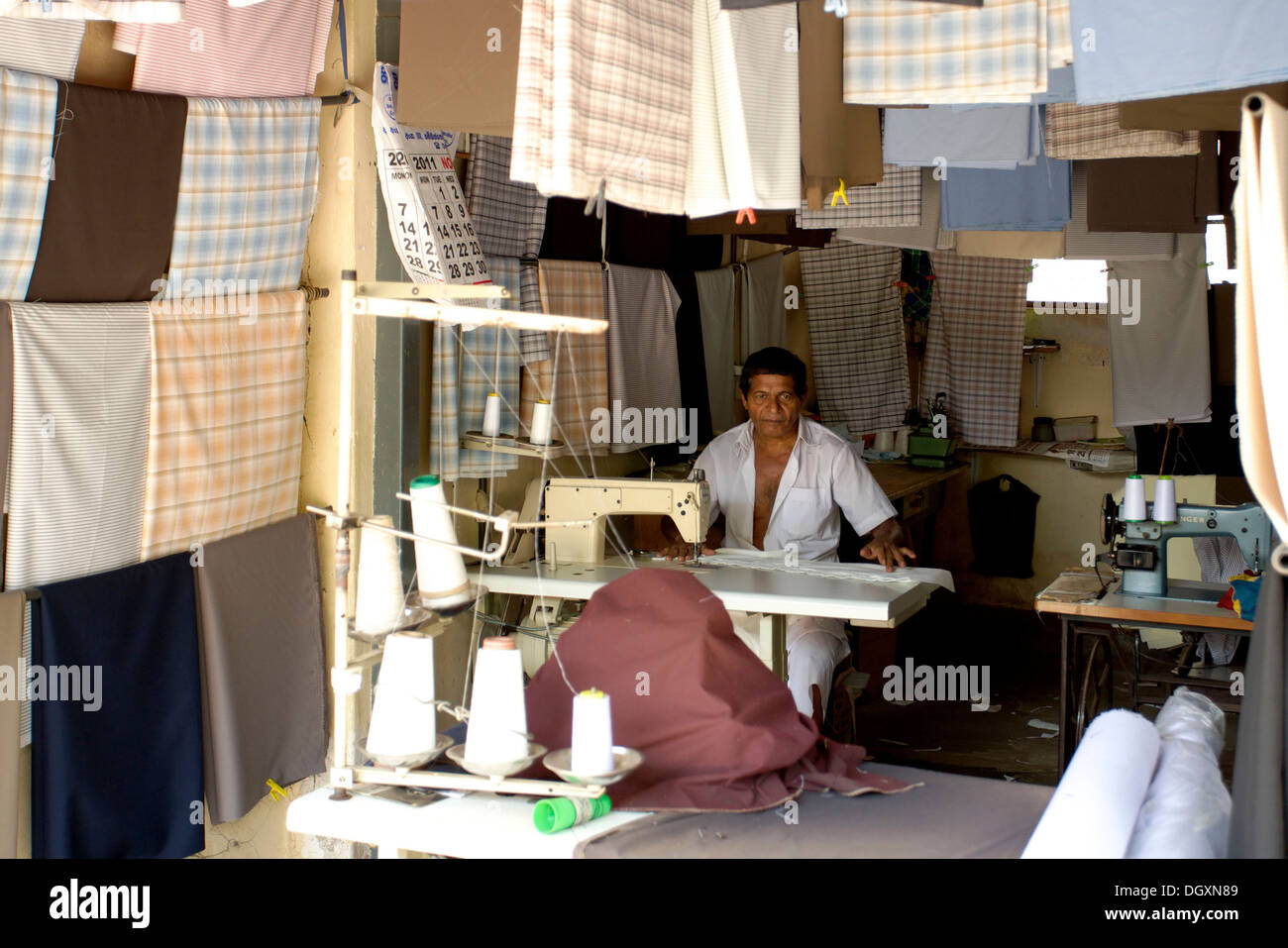 Sinhalese tailor amidst his materials at the market, Tangalle, Sri Lanka, Asia Stock Photo