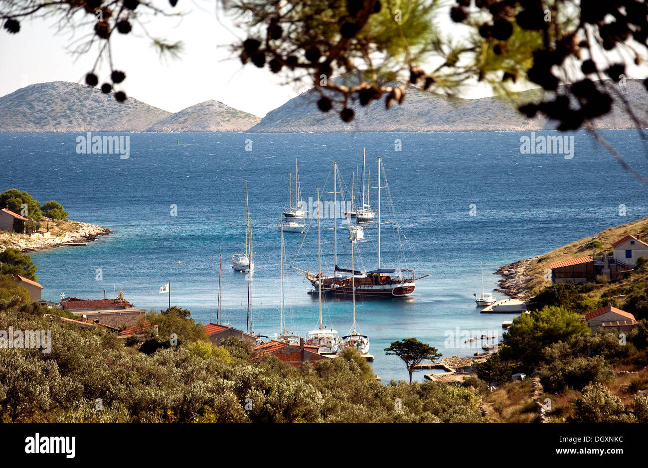 Sailboats, including a traditional gulet, moor in Croatia's Smokvika bay with more of the Kornati islands beyond Stock Photo
