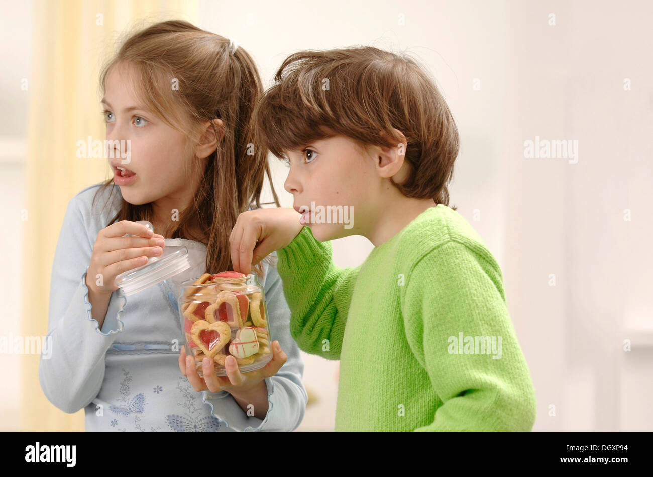 Girl and boy nibbling on Christmas cookies Stock Photo