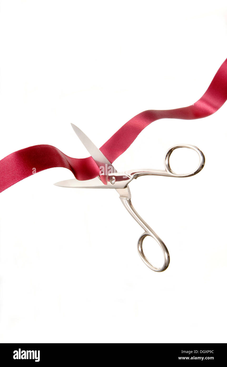 Scissors cutting a red ribbon Stock Photo
