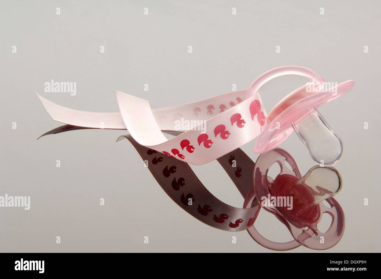 Pink pacifier on a ribbon with a duck motif Stock Photo - Alamy