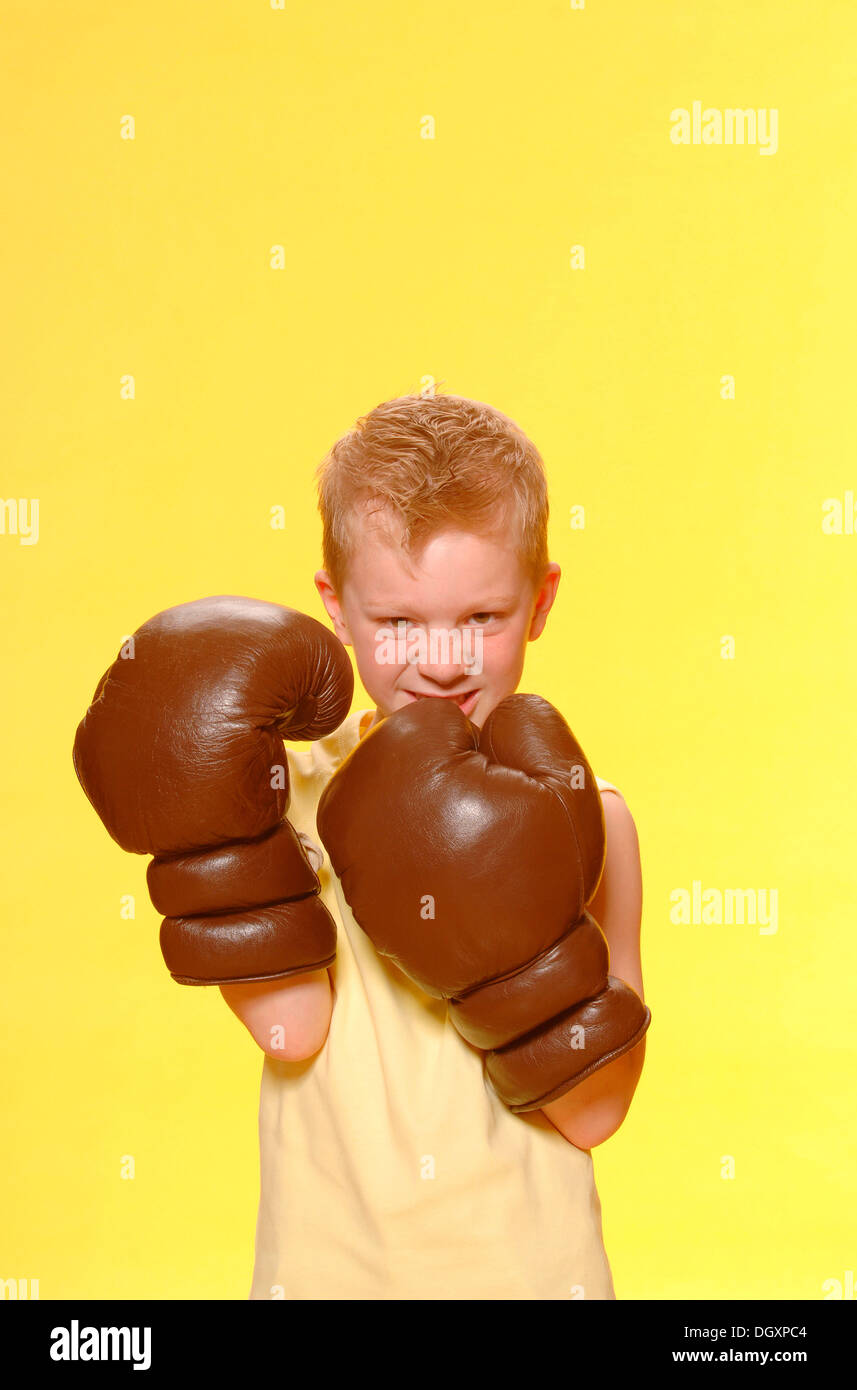 Boy, 6, wearing oversized boxing gloves Stock Photo