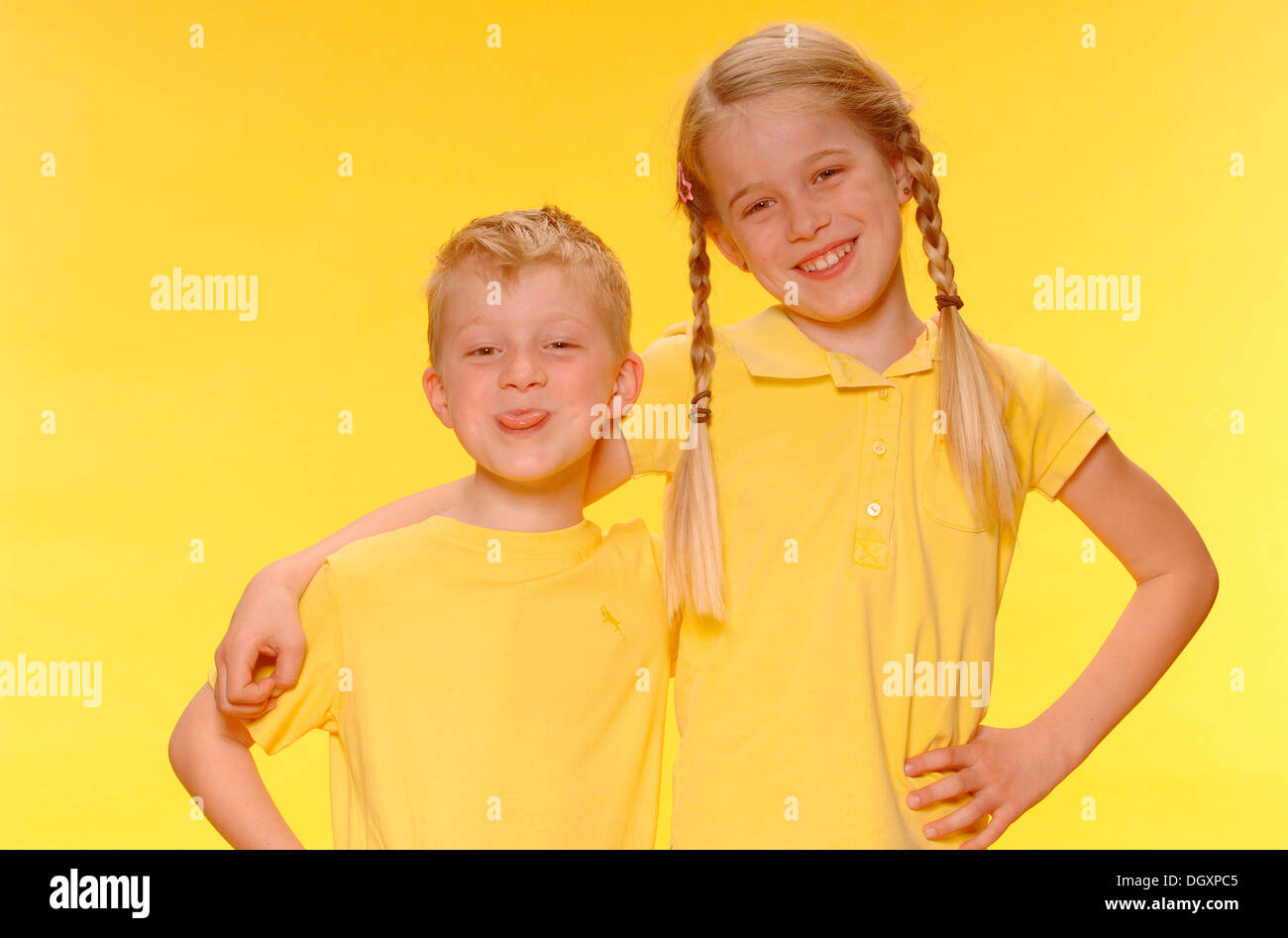 Boy and girl, brother and sister, standing arm in arm, smiling Stock Photo