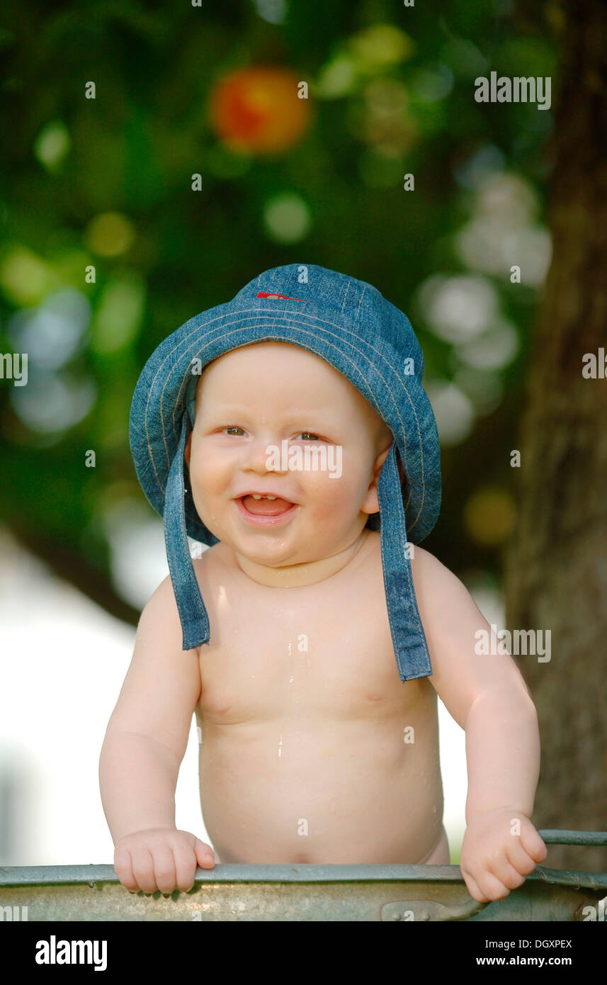 Baby, one year, bathing in a zinc tub outdoors Stock Photo
