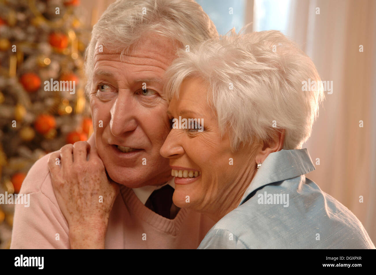 Mature couple in love in front of a Christmas tree Stock Photo
