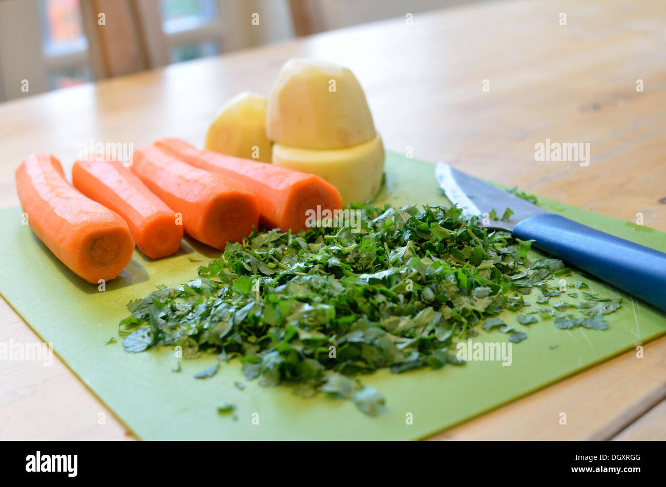 Chopped vegetables and herbs on a chopping board Stock Photo