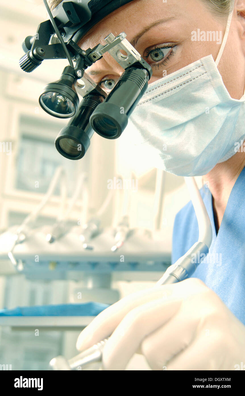 Dentist, dental hygienist, wearing a face mask and magnifying loupes Stock Photo