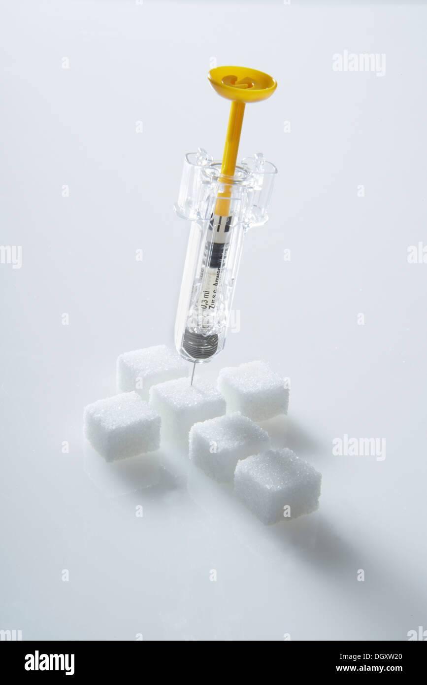 Sugar cubes in a cross-shape with a syringe filled with insulin, insulin injection Stock Photo