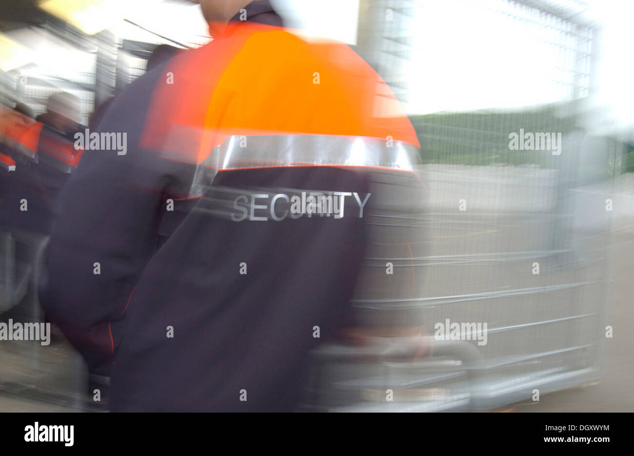 Man wearing a security jacket, blurred from behind Stock Photo
