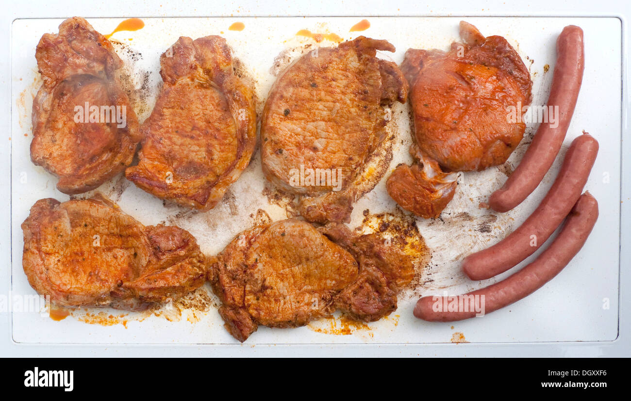 Grilled pork steaks and sausages on an electric grill, electric cooker Stock Photo