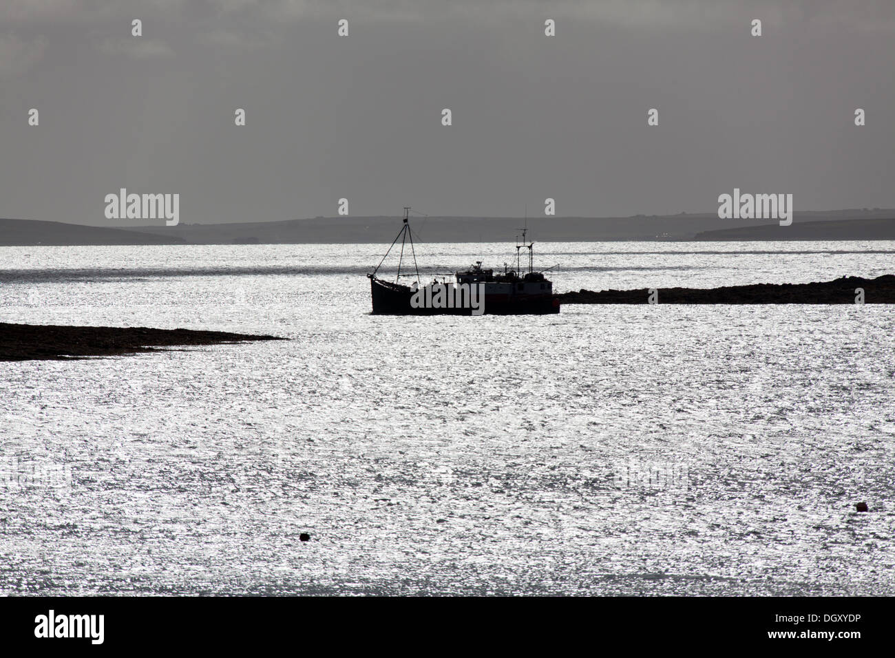 Islands of Orkney, Scotland. Picturesque silhouetted view of a ferry leaving the Houton ferry terminal in the Bay of Houton. Stock Photo