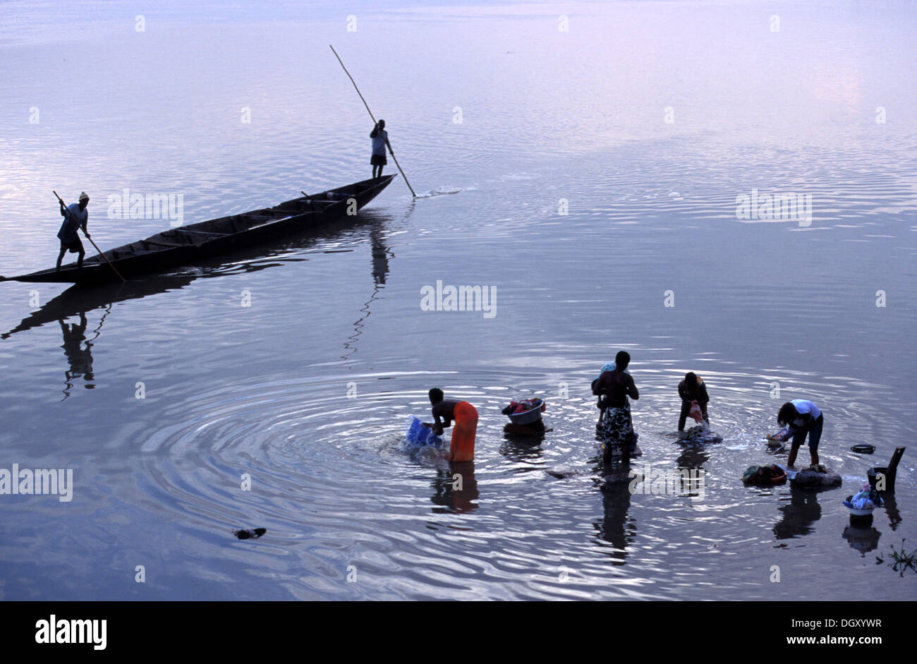 Women washing in River Nicer with two men rowing in a traditional boat