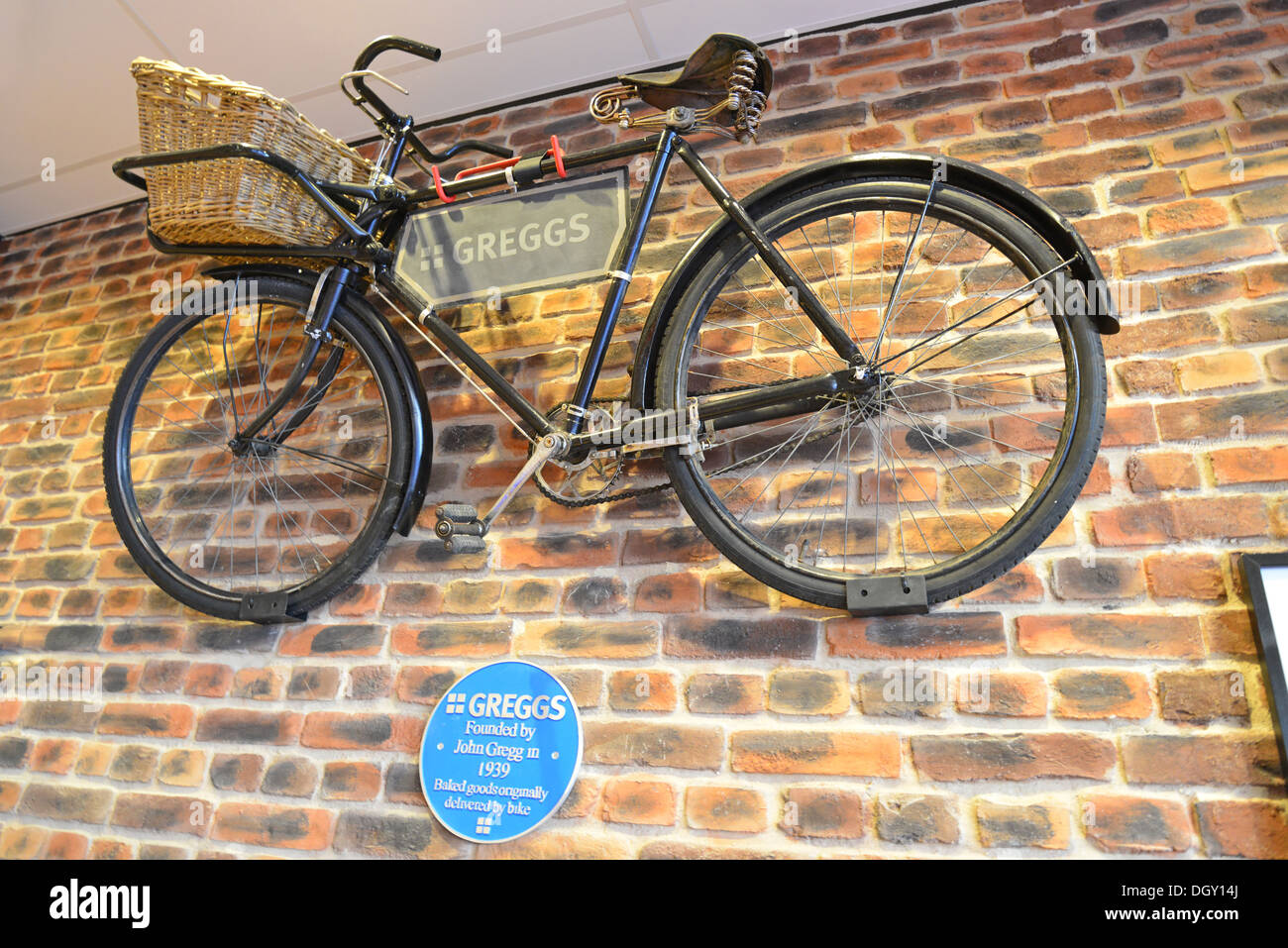 Old delivery bicycle on wall of Greggs Bakery, High Street, Haverhill, Suffolk, England, United Kingdom Stock Photo