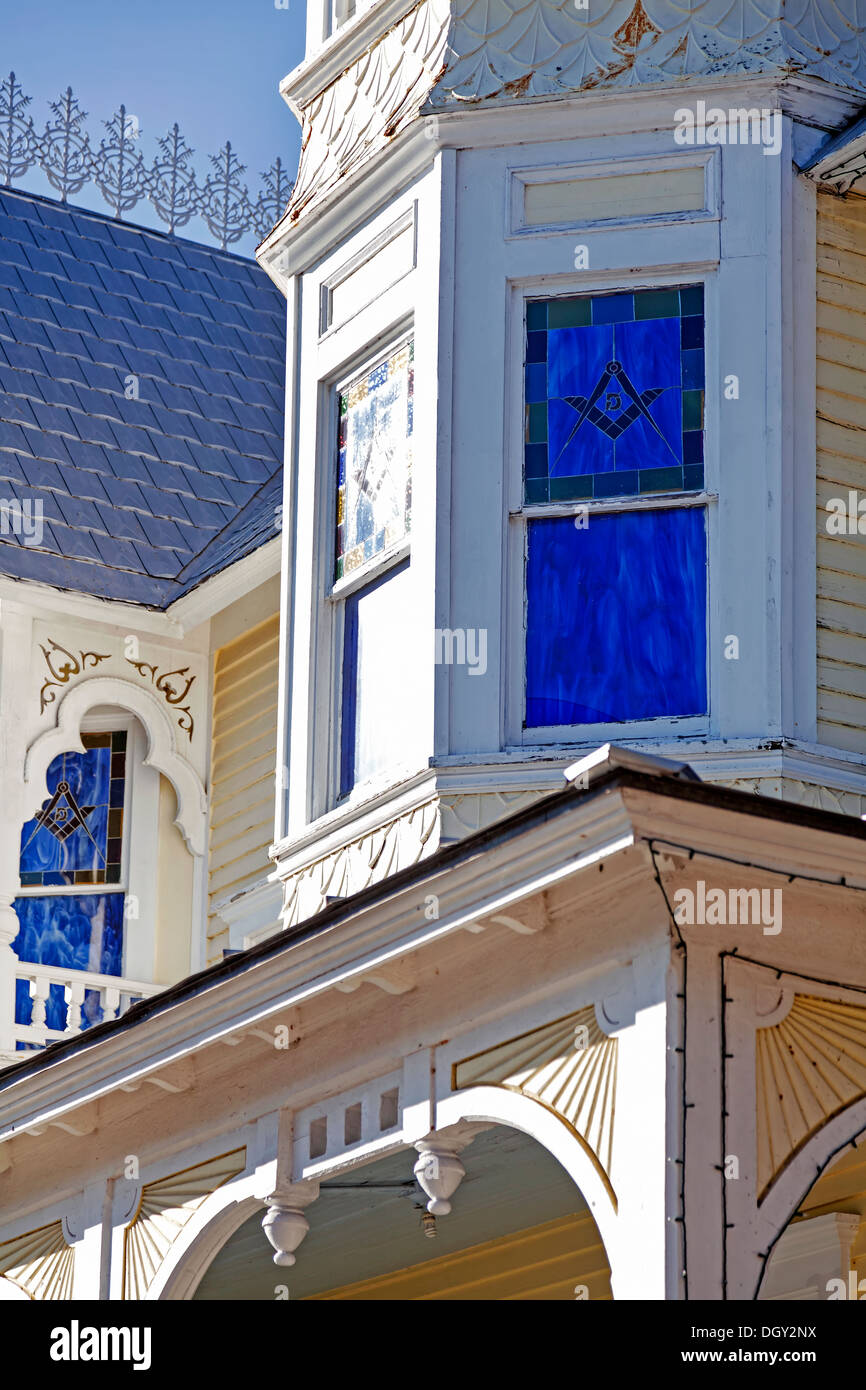Cobalt blue stained glass windows, octagonal tower turret and gingerbread details on old Victorian house in Mount Dora, Florida. Stock Photo
