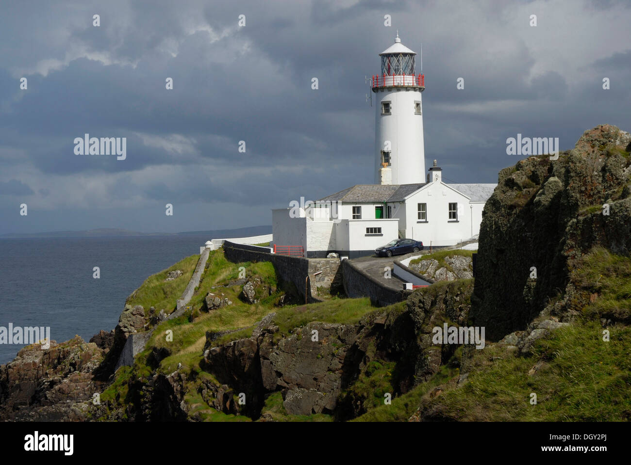 Fanad Head Lighthouse on rocky cliff, rain shower, County Donegal, Ireland, Europe Stock Photo