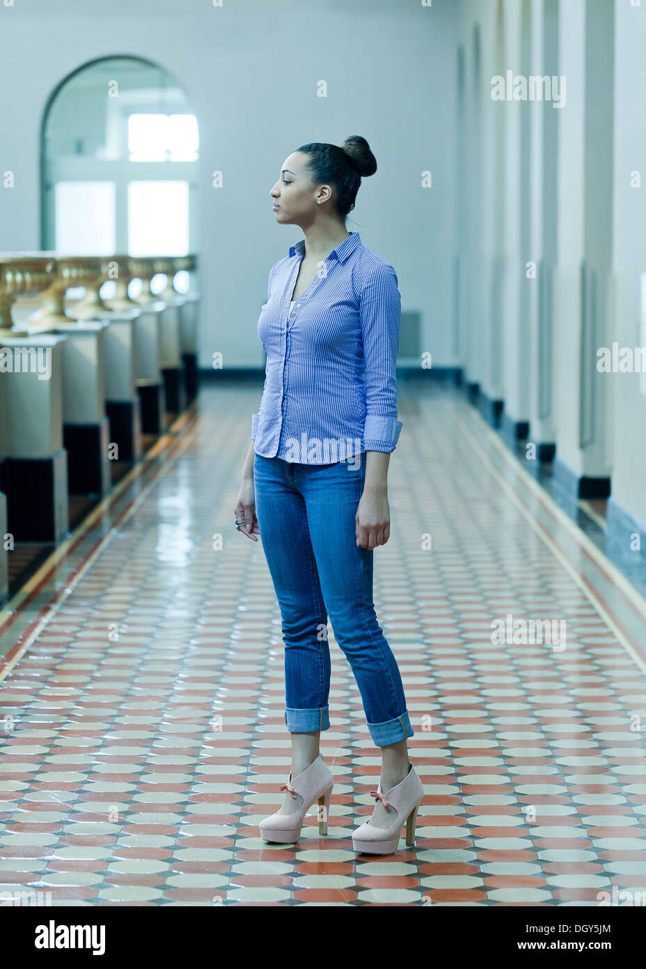 African-American woman standing on colorful tile floor Stock Photo