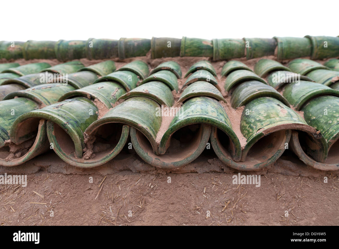 Close up of edge of green Qarmud roof tiles on a mud brick building Morocco Stock Photo