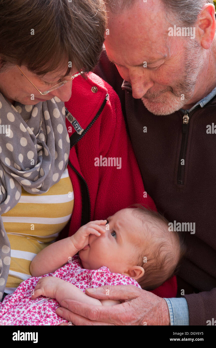 Grandparents holding and cuddling their little granddaughter Stock Photo