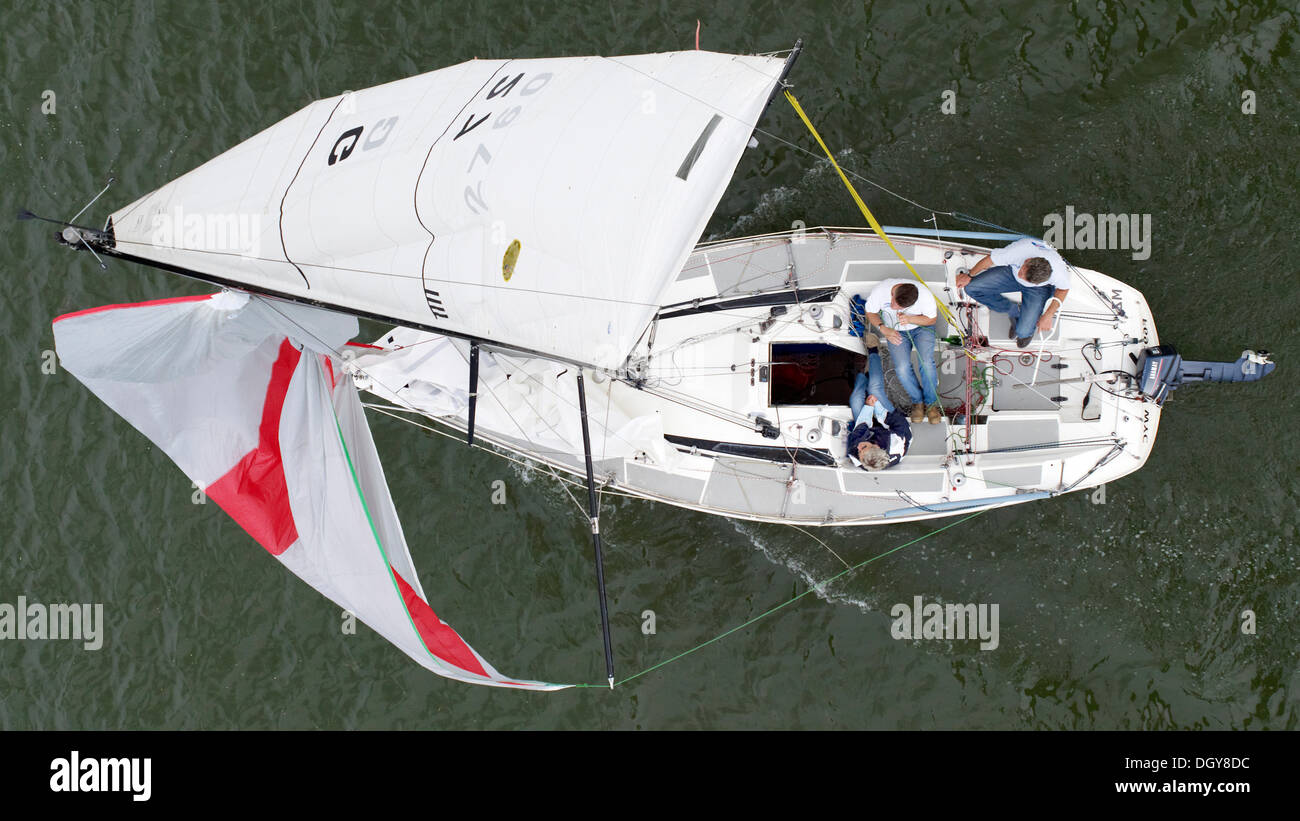 Topview of a yacht with a jib and 3 men on board Stock Photo