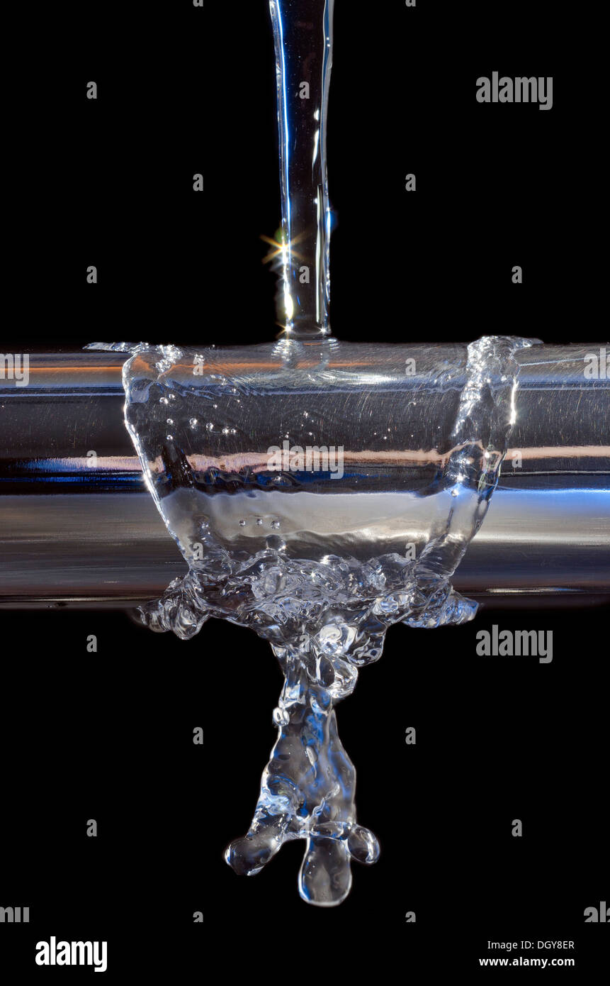 Closeup of water falling on a metal bar Stock Photo