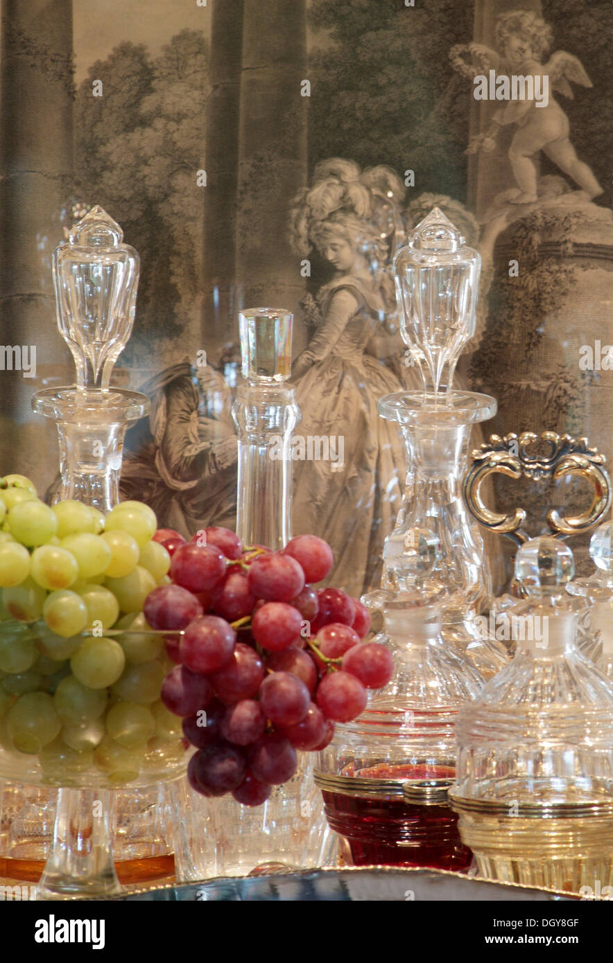 Still Life with grapes in fine, stylish glasses in front of antique glass decanters in a luxurious ambience Stock Photo