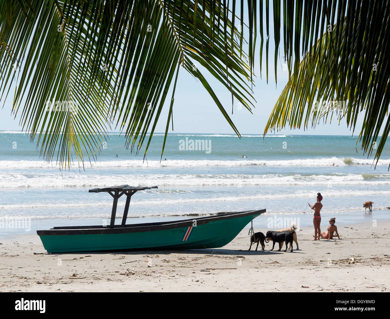 Boat, Costa Rican women and dogs on the beach, Playa Samara, Nicoya Peninsula, Costa Rica, Central America Stock Photo