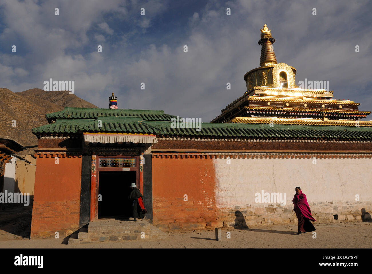 A Tibetan monk in front of the large golden stupa of the Tibetan Labrang monastery, Xiahe, Gansu, China, Asia Stock Photo