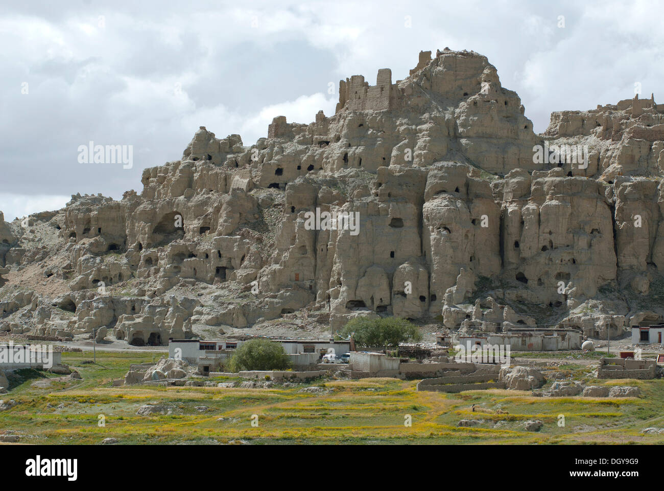 Dungkar caves with Tibetan village at front built in the traditional architectural style of the Tibetans in the ancient Kingdom Stock Photo