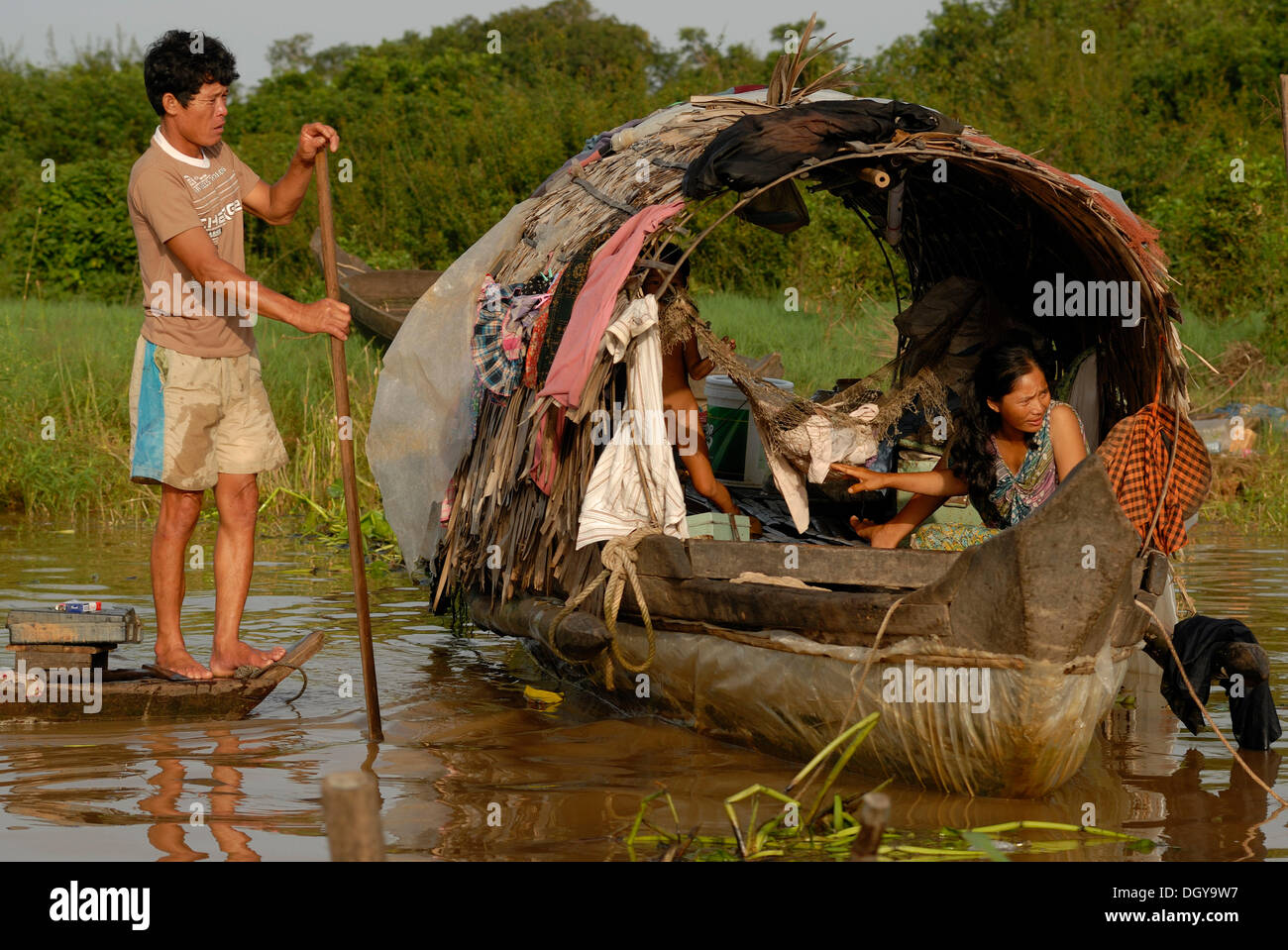 Poor Floating Poor Cambodian residents of the floating villages on a barge with a sun ...