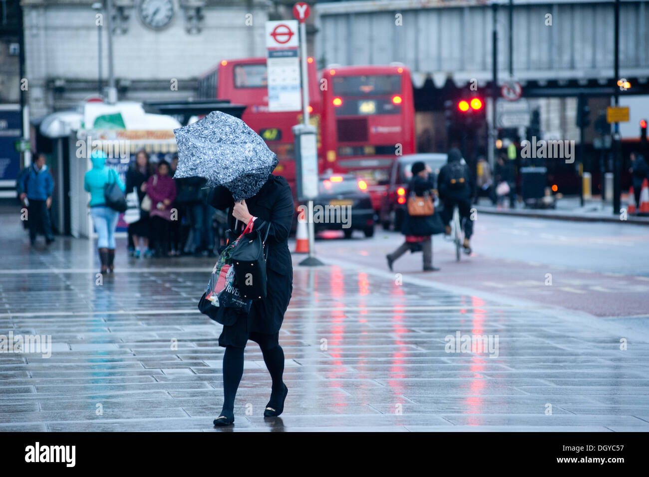 London, UK - 28 October 2013: a woman crossing London Bridge struggles with her umbrella as the city is hit by the storm. The storm, called St Jude, brought the windiest weather to hit the UK since 1987.  Credit:  Piero Cruciatti/Alamy Live News Stock Photo