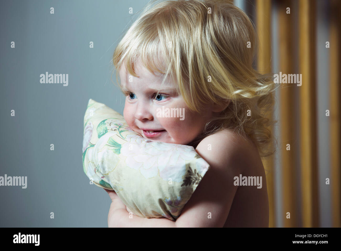 Blonde haired girl hugging pillow Stock Photo