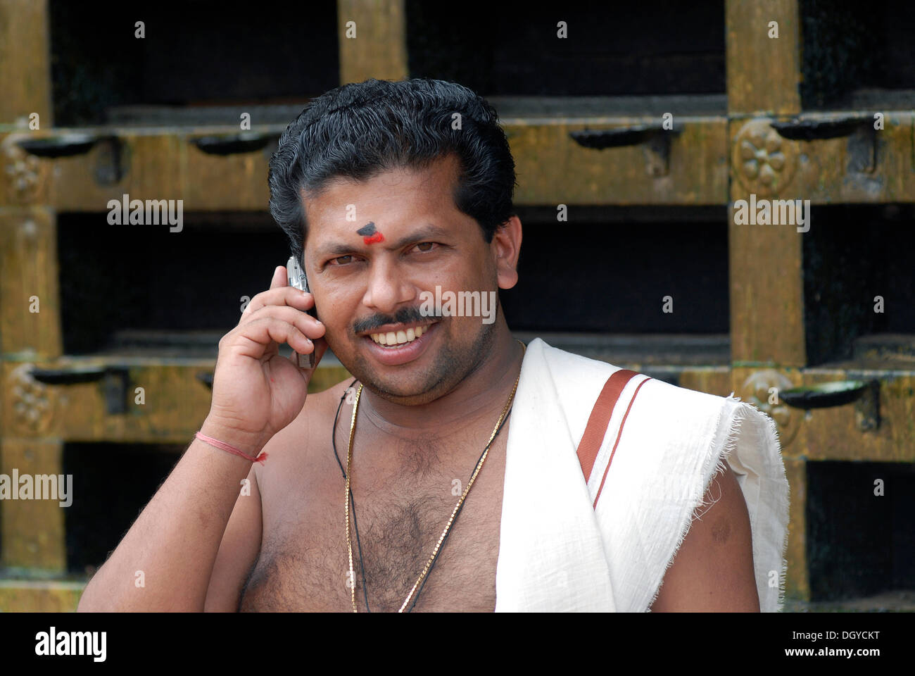 Hindu priest talking on a mobile phone, temple of Ettumanur, Kerala, South India, India, Asia Stock Photo