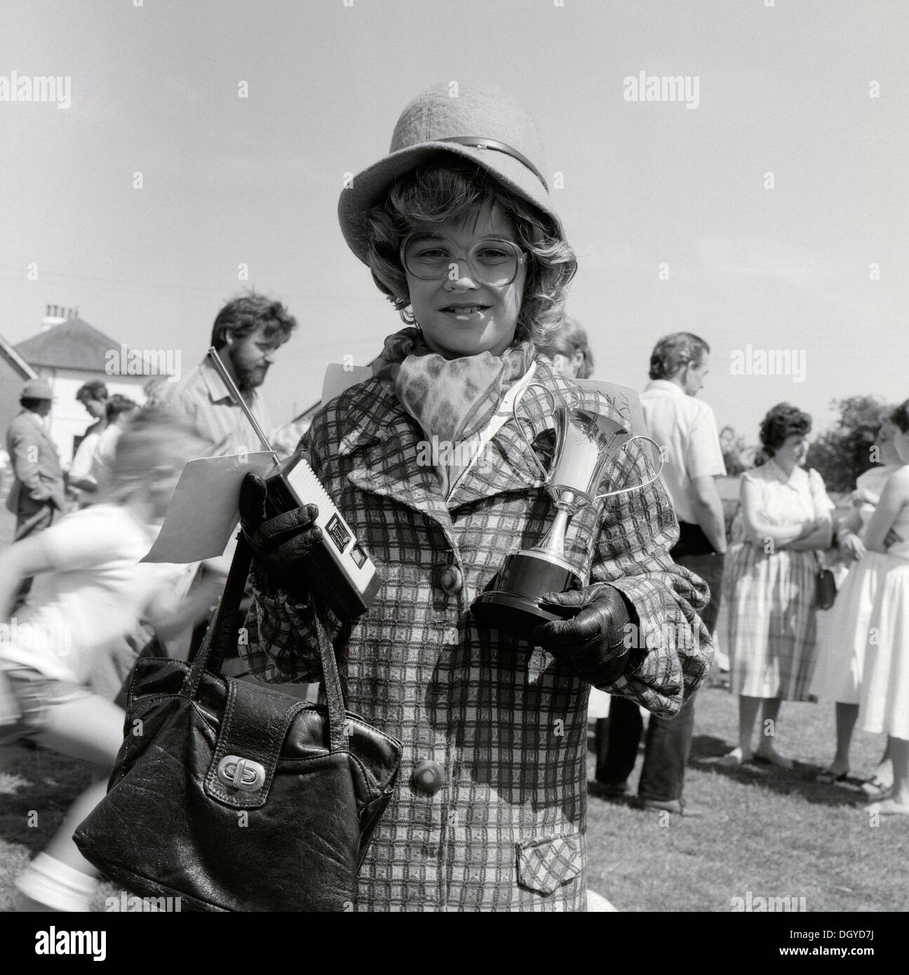 Boy with CB radio dressed in old woman's clothing (PM Mrs. Thatcher) holding a silver cup for winning a fancy dress competition at Llanwrda community carnival  in Carmarthenshire Dyfed Wales UK Great Britain  KATHY DEWITT Stock Photo