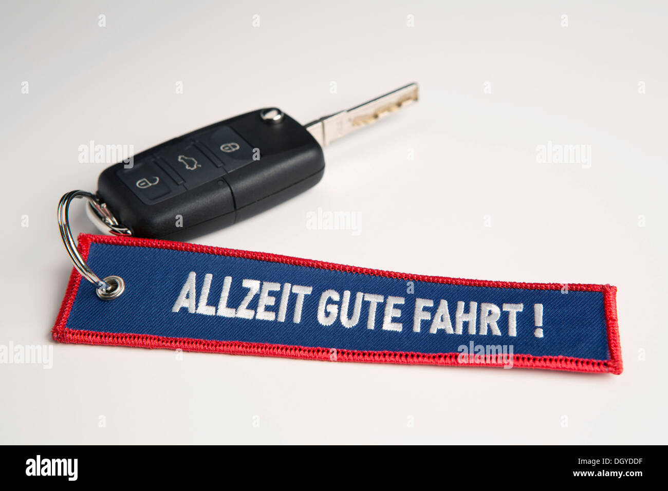 A car key and keychain with the phrase Always Drive Good in German Allzeit Gute Fahrt! Stock Photo