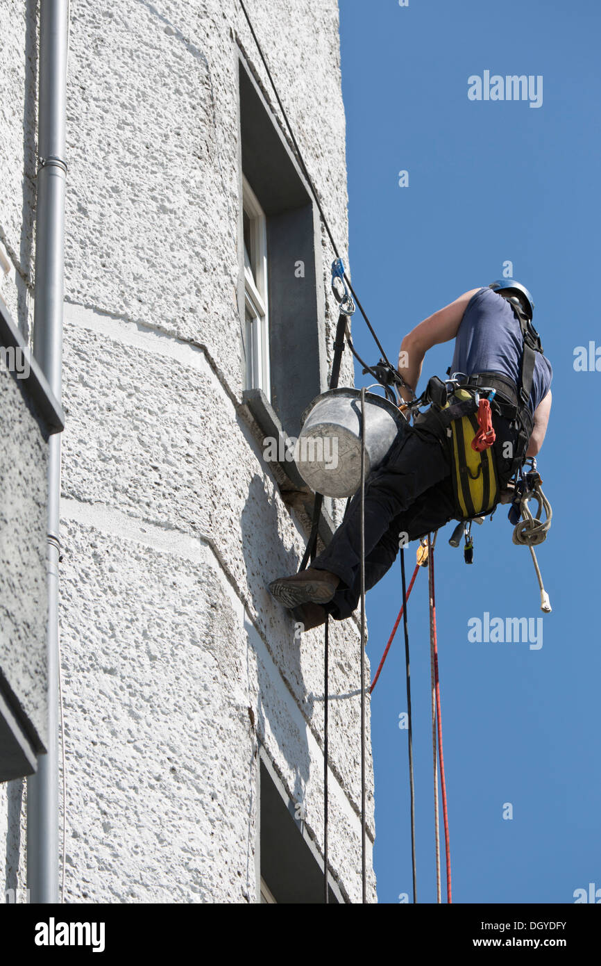 A window washer suspended on a rope Stock Photo
