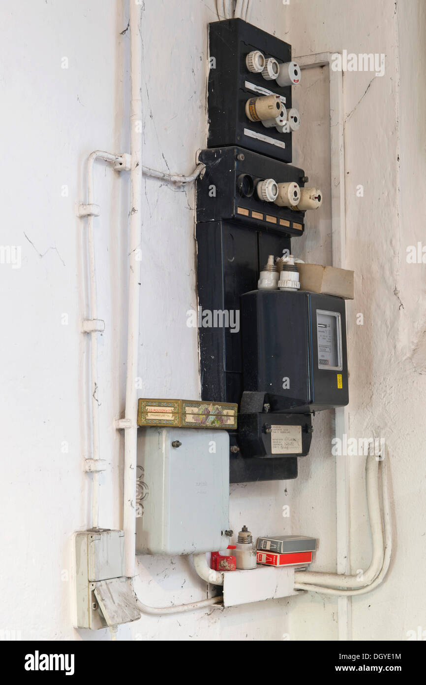 Old fuse box with an electricity meter and electrical wiring on a wall in a basement of an old building, Stuttgart Stock Photo