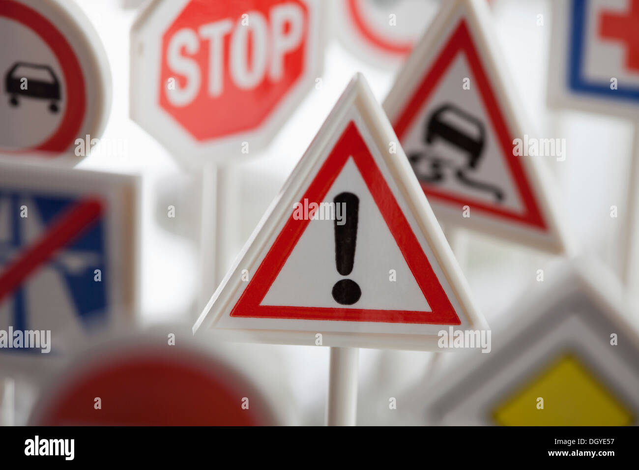 A toy hazard sign surrounded by other various road warning signs Stock Photo